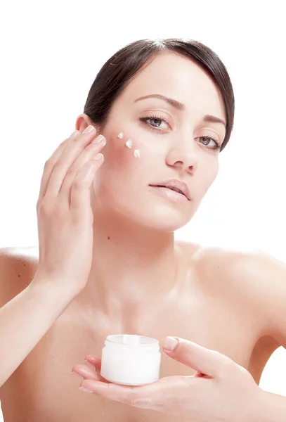 Beautiful woman applying cosmetic cream treatment on her face — Stock Photo, Image