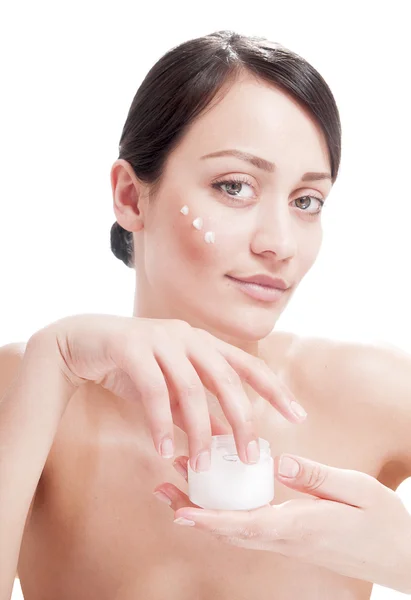 Beautiful woman applying cosmetic cream treatment on her face — Stock Photo, Image