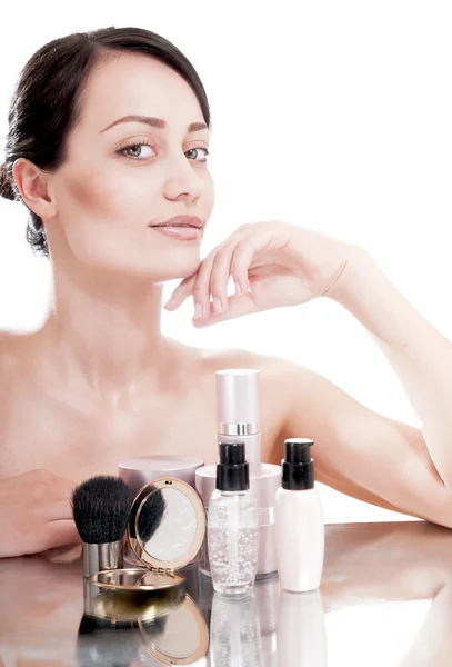 Kvinna med en bra hy nära krämer kosmetika — Stockfoto
