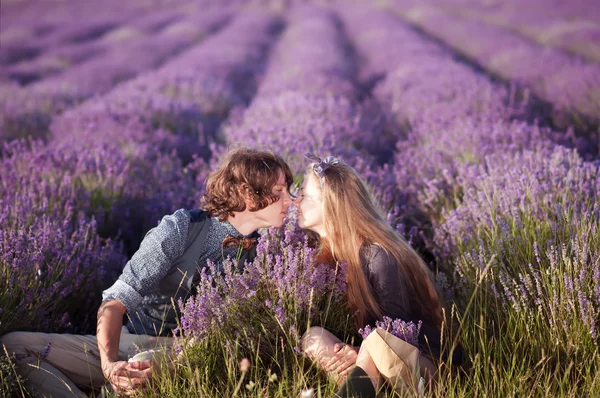 Beau jeune couple assis dans un champ de lavande . — Photo