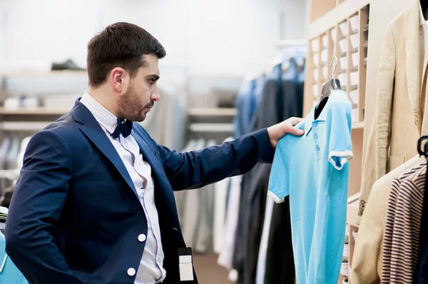 Joven atractivo comprando una camiseta — Foto de Stock