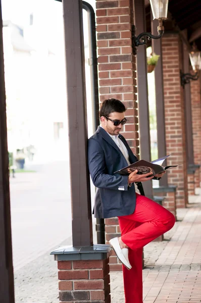 时尚英俊的男人，阅读一本杂志上散步. — 图库照片