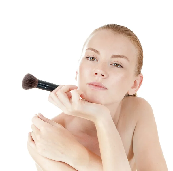 Young beautiful girl applying makeup by brush on her face. — Stock Photo, Image