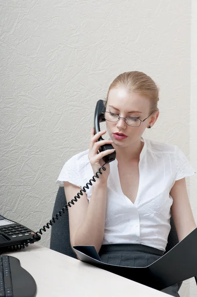 Práce úřadu holka na telefonu a dívá se na černé složky — Stock fotografie