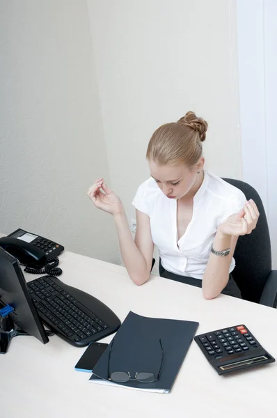 Tired young  businesswoman meditating at the computer. — Stock Photo, Image