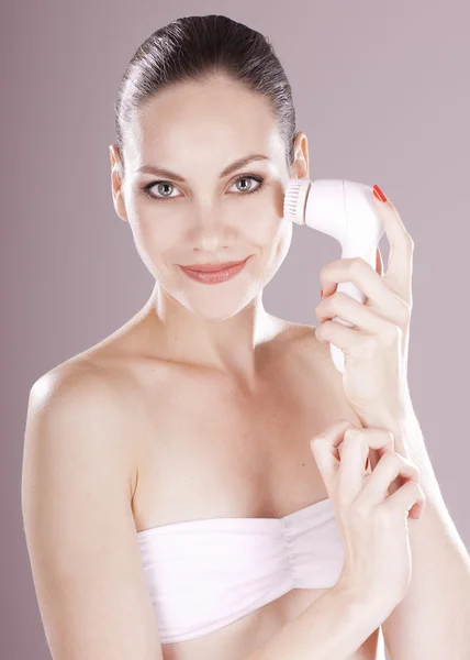 Encantadora mujer con cepillo para limpieza facial profunda — Foto de Stock