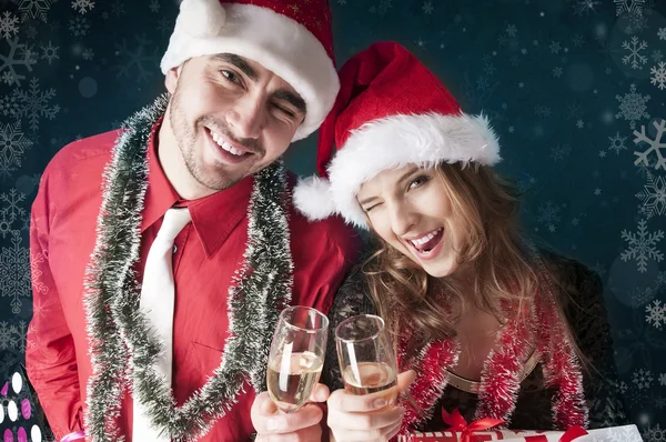 Happy Christmas couple with glasses of champagne covering — Zdjęcie stockowe
