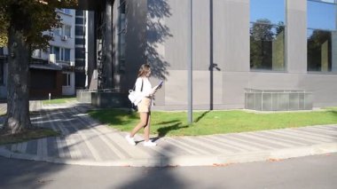 İş kadını işe giderken modern binanın önünden geçen belgelere göz atıyor.