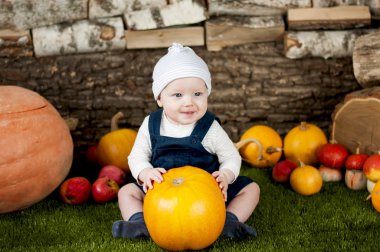 Çimenlerin üzerinde birçok farklı kabak ile bebek.