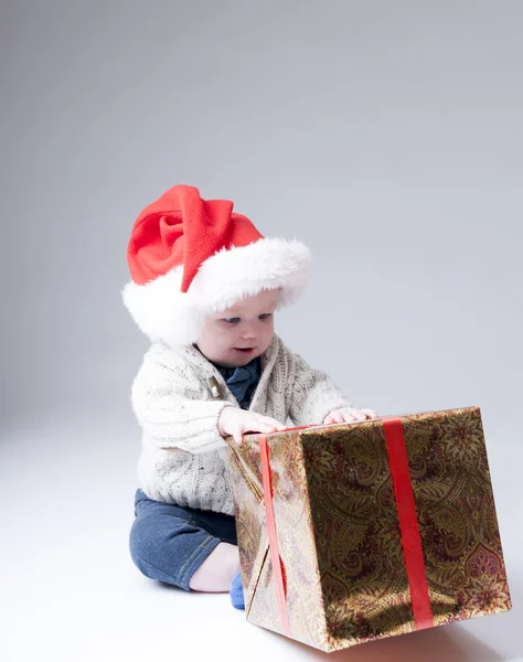 Vicces baba Santa kalap játék-val egy nagy ajándék doboz. — Stock Fotó
