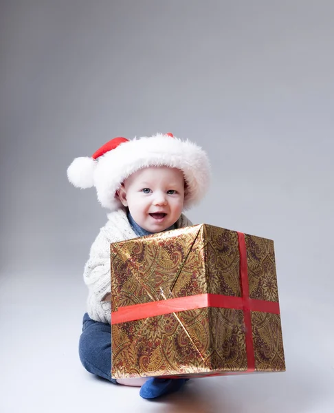 Vicces baba Santa kalap játék-val egy nagy ajándék doboz. — Stock Fotó