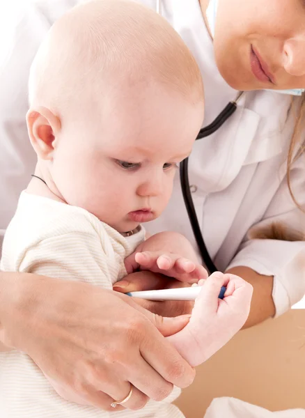 Enfermera mide la temperatura de un bebé, aislado en la espalda blanca —  Fotos de Stock