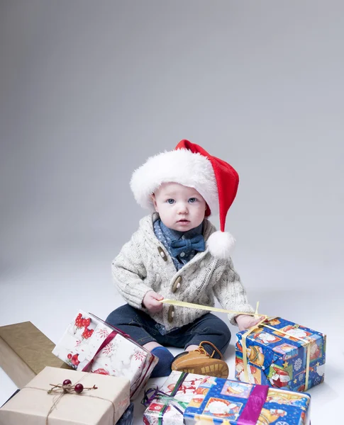 Vidám baba ajándék dobozok viselt santa kalap — Stock Fotó