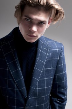 ciddi bir adam gri arka plan üzerinde bir palto giyiyor.