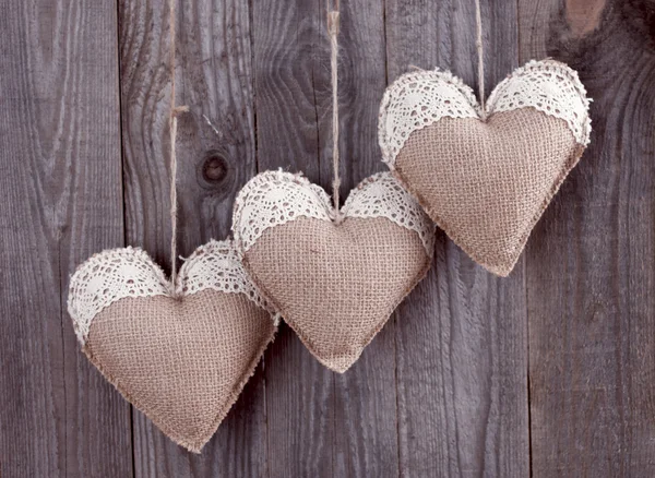 Three sackcloth handmade hearts with lace — Stock Photo, Image