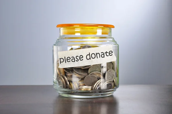 Saving concept of coins in the glass jar for please donate  purp — Stock Photo, Image