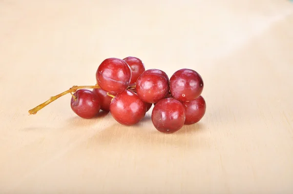 Delicious bunch red seedless crimson grape on wood plank — Stock Photo, Image