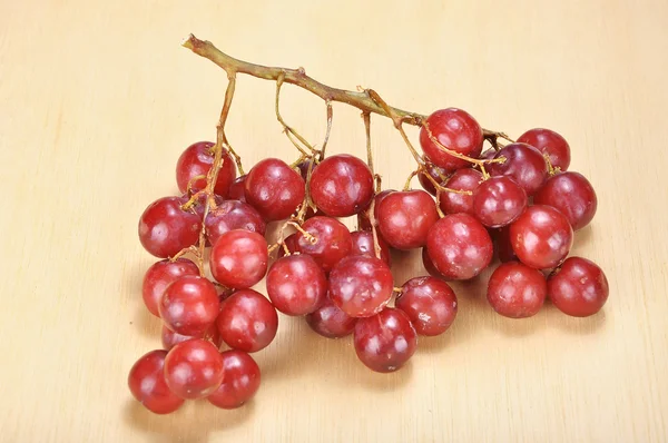 Delicious bunch red seedless crimson grape on wood plank — Stock Photo, Image
