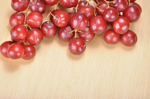 Kilka pyszne czerwone bez pestek winogron szkarłatny na drewno deski — Zdjęcie stockowe