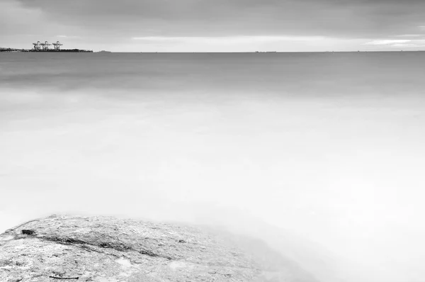 Rock alacakaranlık çarpıcı sırasında isabet dalganın uzun pozlama — Stok fotoğraf