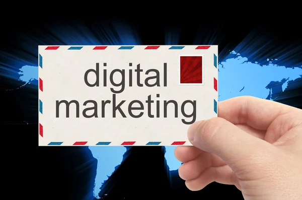 Envelope mão segurando com palavra de marketing digital no mundo backg — Fotografia de Stock