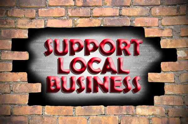 Podpora místního podnikání v díře cihlová zeď — Stock fotografie