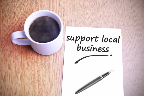 Caffè sul tavolo con annotazione scrittura supporto locale business — Foto Stock