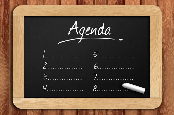 Kreidetafel auf dem Holztisch schriftliche Agenda-Liste — Stockfoto