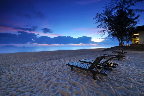 Las sillas de playa en la playa de arena al amanecer o al atardecer — Foto de Stock
