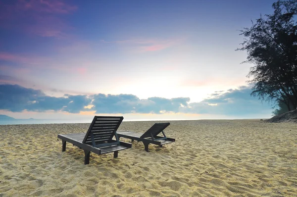 Las sillas de playa en la playa de arena al amanecer o al atardecer — Foto de Stock