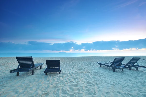 Las sillas de playa en la playa de arena al amanecer o al atardecer — Foto de Stock