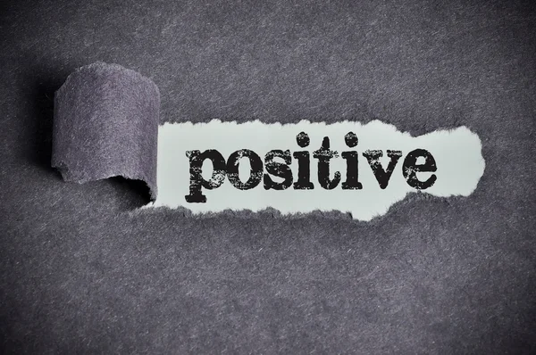 Positive word under torn black sugar paper — Stock Photo, Image