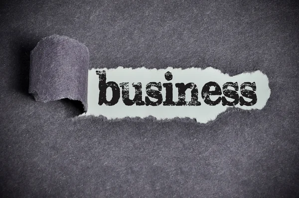 Business word under torn black sugar paper — Stock Photo, Image