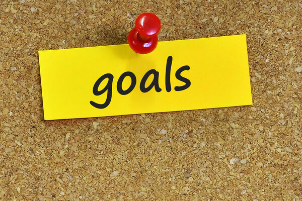 Цели word on notes paper with cork background
