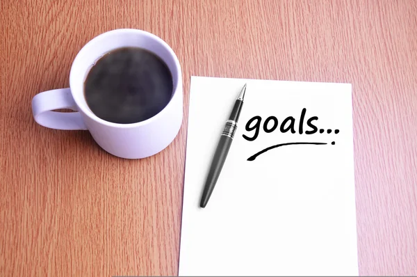 Kaffe, penna och anteckningar skriva mål — Stockfoto
