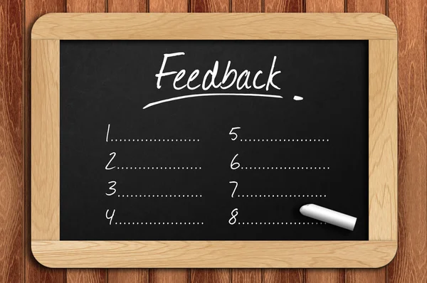 Schoolbord op de houten tafel geschreven feedback lijst — Stockfoto