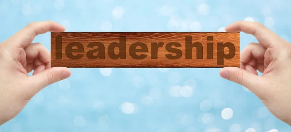 Руки с гравировкой на дереве со словом "лидерство" — стоковое фото