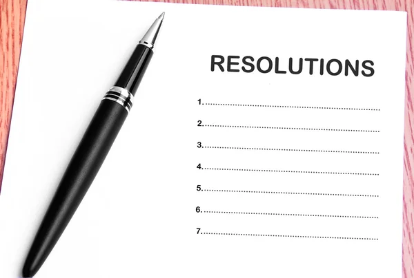 Ручка і нотатки паперу зі списком резолюцій — стокове фото