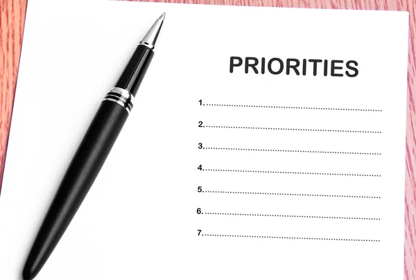 Ручка и заметки бумаги со списком приоритетов — стоковое фото