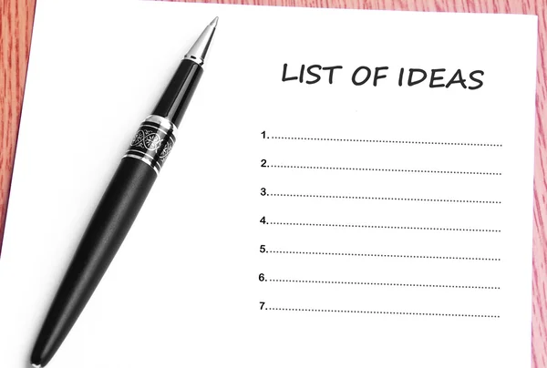 Ручка и заметки бумаги со списком идей — стоковое фото