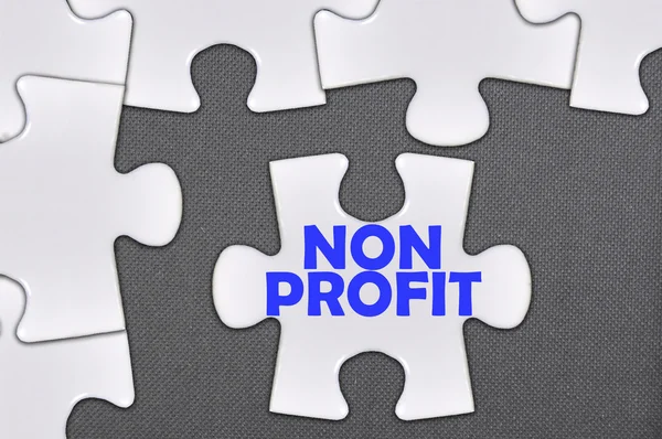 Jigsaw puzzle geschreven woord non-profit — Stockfoto