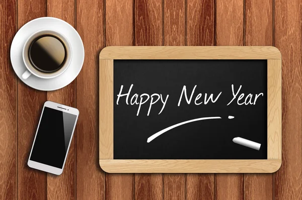 Café, teléfono y pizarra con palabra feliz año nuevo — Foto de Stock
