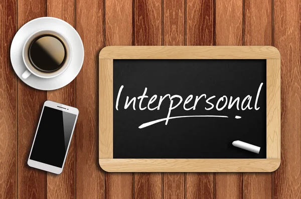 Café, teléfono y pizarra con palabra interpersonal — Foto de Stock