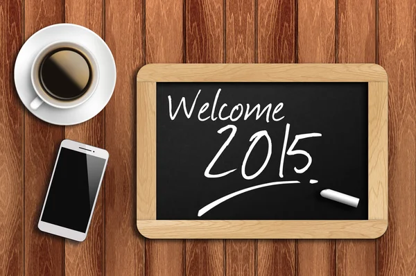 Kaffee, Telefon und Tafel mit Wort willkommen 2015 — Stockfoto