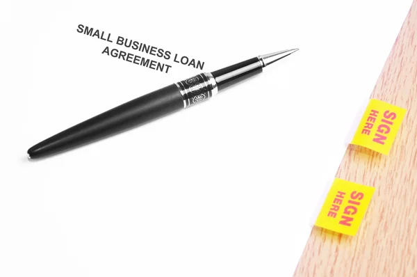 Pluma negra y acuerdo de préstamo para pequeñas empresas con signo aquí Stick —  Fotos de Stock