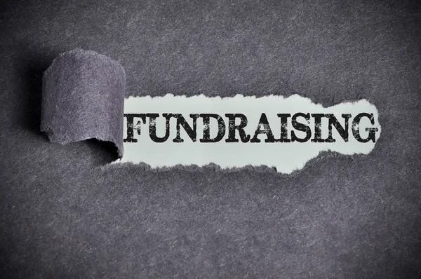 Fundraising word under torn black sugar paper — Stock Photo, Image