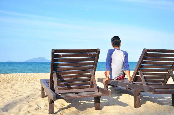 Hombre sentarse en la silla de playa en la playa de arena. Concepto de descanso, relajación, vacaciones . —  Fotos de Stock