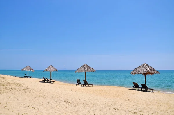 Sillas de playa y sombrillas en una hermosa vista panorámica de la playa a — Foto de Stock