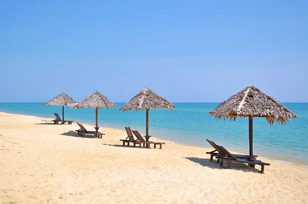 Sillas de playa y sombrillas en una hermosa vista panorámica de la playa a — Foto de Stock