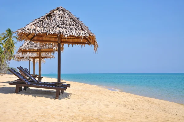 Sillas de playa y sombrillas en una hermosa vista panorámica de la playa a — Foto de Stock